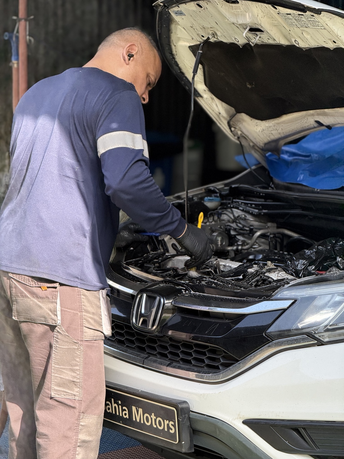 Mecánico de Grand Motor trabajando en el motor de un vehículo